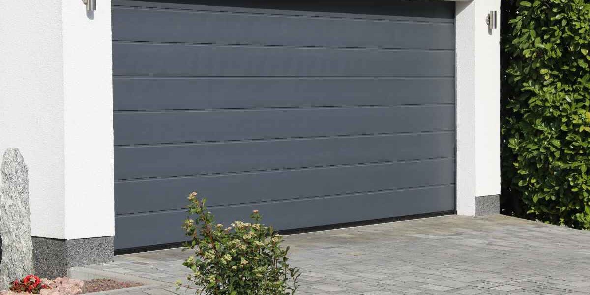 ISOL-porte-garage-sectionnelle Porte de garage sectionnelle grise sur une maison en crépi blanc