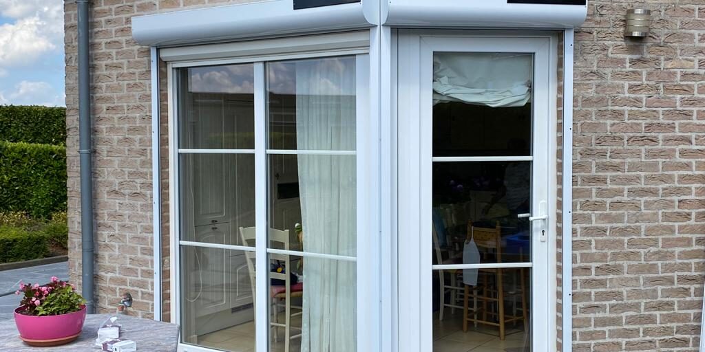 73c738e5-5be6-42f6-898d-cd69ccb877d5 Volet solaire en PVC blanc sur une maison en brique