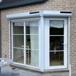 Volet solaire en PVC blanc sur une maison en brique