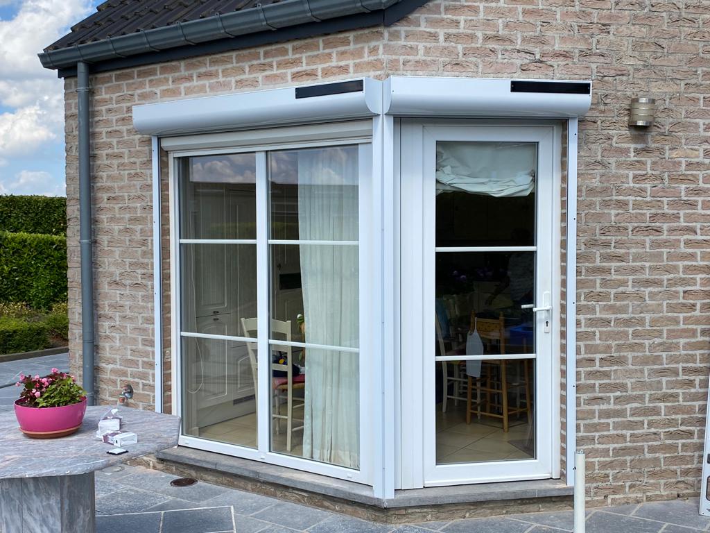 Volet solaire en PVC blanc sur une maison en brique